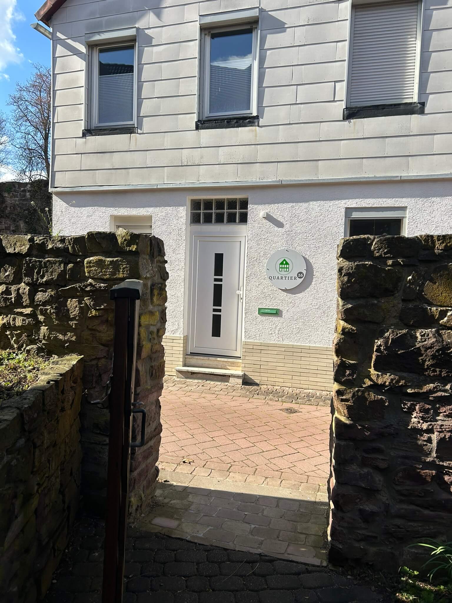 Quartier 26 – Eingang mit Haustür und Natursteinmauer