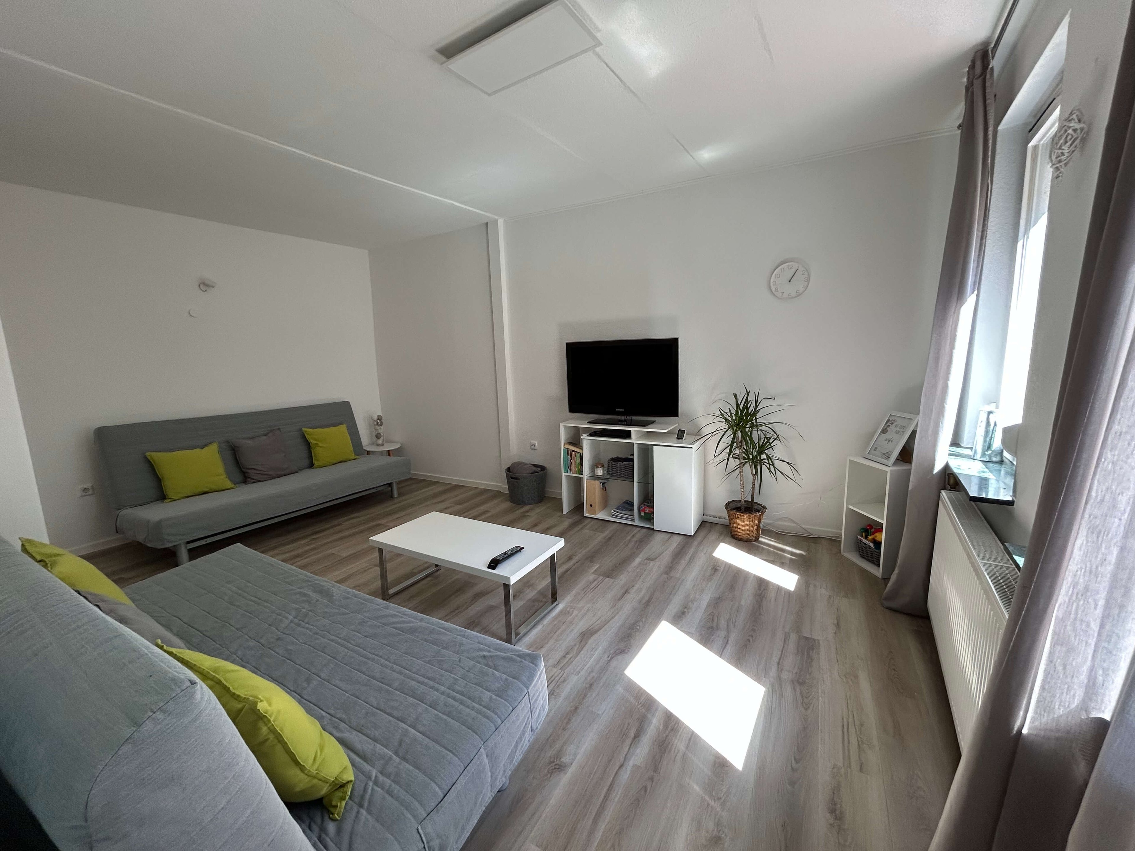 Quartier 26 – Wohnzimmer mit zwei Schlafcouchen und TV
